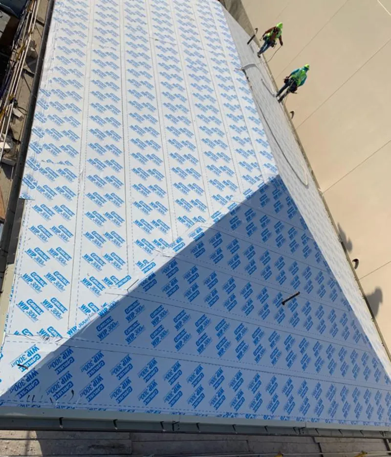 Professional roofers installing underlayment on a metal roof in Douglass